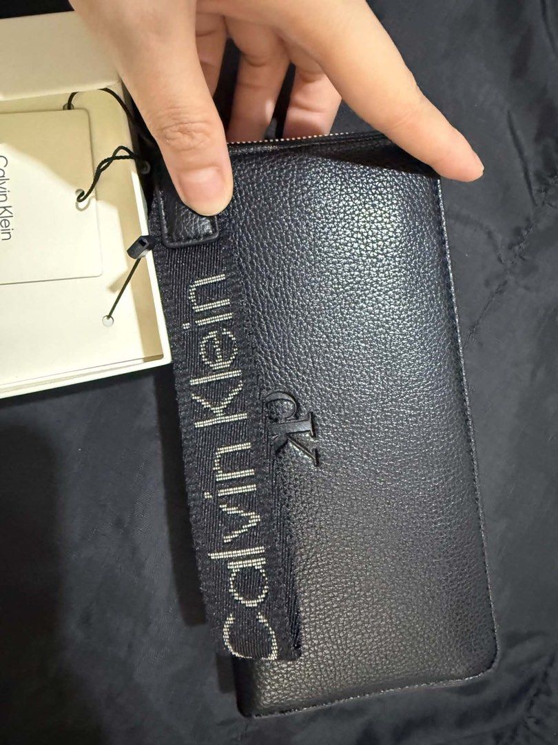 Authentic Calvin Klein Black Leather Zip Around Wristlet Wallet (Category: Wallets & Card holders) located in Manila. Submitted by deoksun (Listing ID 1440816542, Image 2). Description: - Authentic Black Calvin Klein wallet - Detachable wrist strap - Multiple card slots and compartments - Built-in RFID blocking card - Comes in original box - Perfect for organizing your essentials NEGOTIABLE .