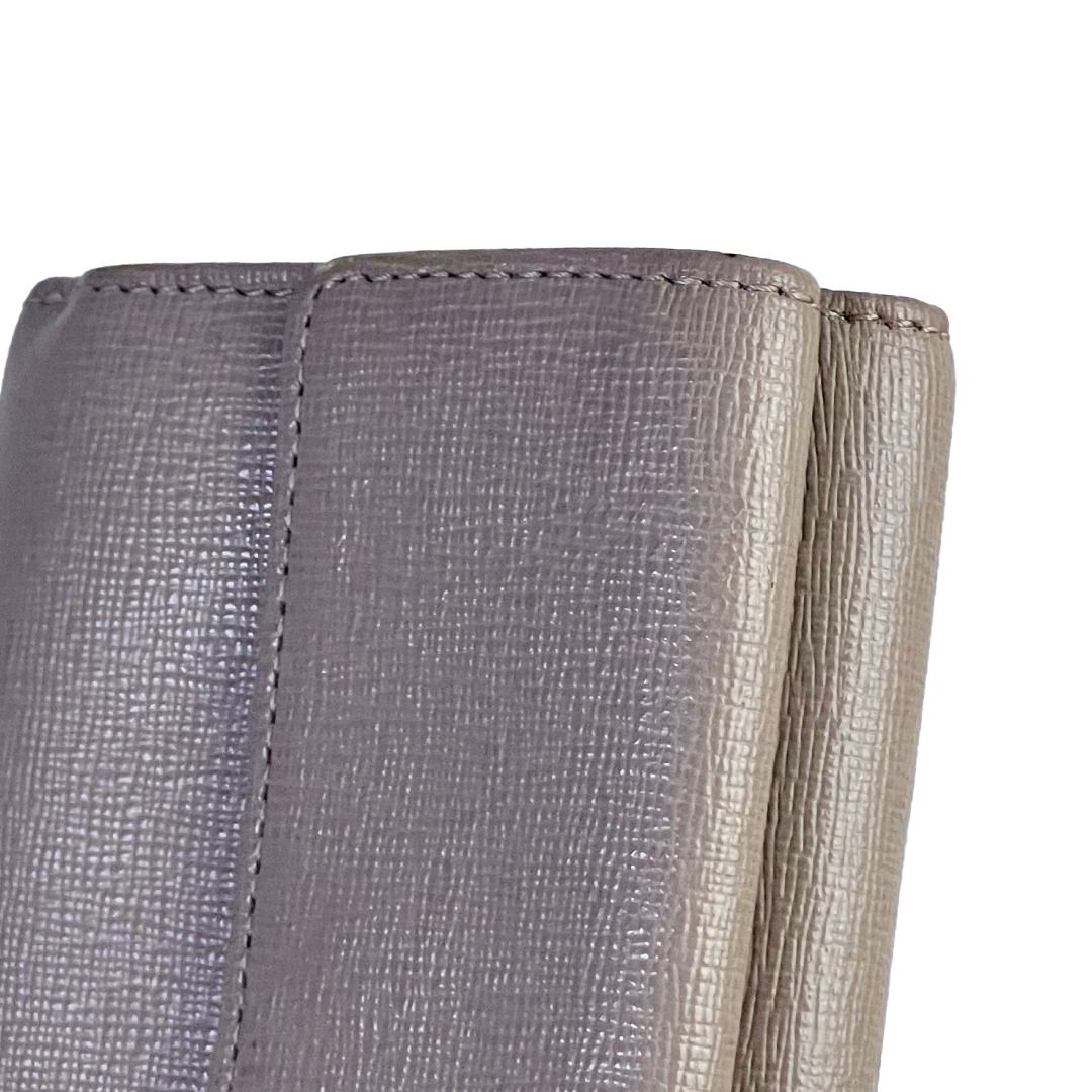 🔴 Sold | Authentic Furla Gray Saffiano Leather Compact Trifold Wallet (Category: Luxury Bags & Wallets) located in Malabon City. Submitted by k.1006 (Listing ID 1440863667, Image 3). Description: • Authentic Furla compact wallet • Gray / taupe-gray leather • Genuine leather construction • Saffiano-textured finish • Compact trifold wallet style • Branded Furla front metal logo plate • Branded Furla hardware details • Black and white tag inside • 