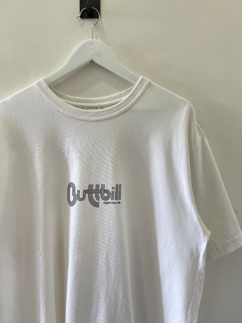 Buttbill Bigher Than Life tee shirt (Category: Tshirts & Polo Shirts ) located in Abucay. Submitted by argarments.ph (Listing ID 1440927972, Image 3). Description: White Buttbill tee. Features the 'Higher Than Life' graphic on the front. Small woven tag on the side seam. Simple, classic fit. Good for everyday wear. Tagged: Medium on tag, fits Large Width 22.5" | Length 29.5" Condition: Great Issue(s): Small dirt stain.