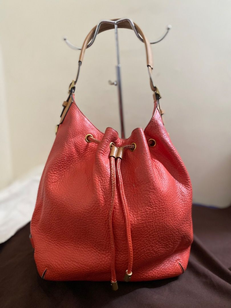 Coach Orange Leather Drawstring Bucket Bag (Category: Luxury Bags & Wallets) located in Paete. Submitted by ladder_leynn (Listing ID 1440817041, Image 1). Description: - Authentic Coach bucket bag vintage - Vibrant orange pebbled leather - Tan leather straps - Secure drawstring closure - Elegant gold hardware details - Interior zip pocket for essentials - Made in China - Ideal everyday bag.