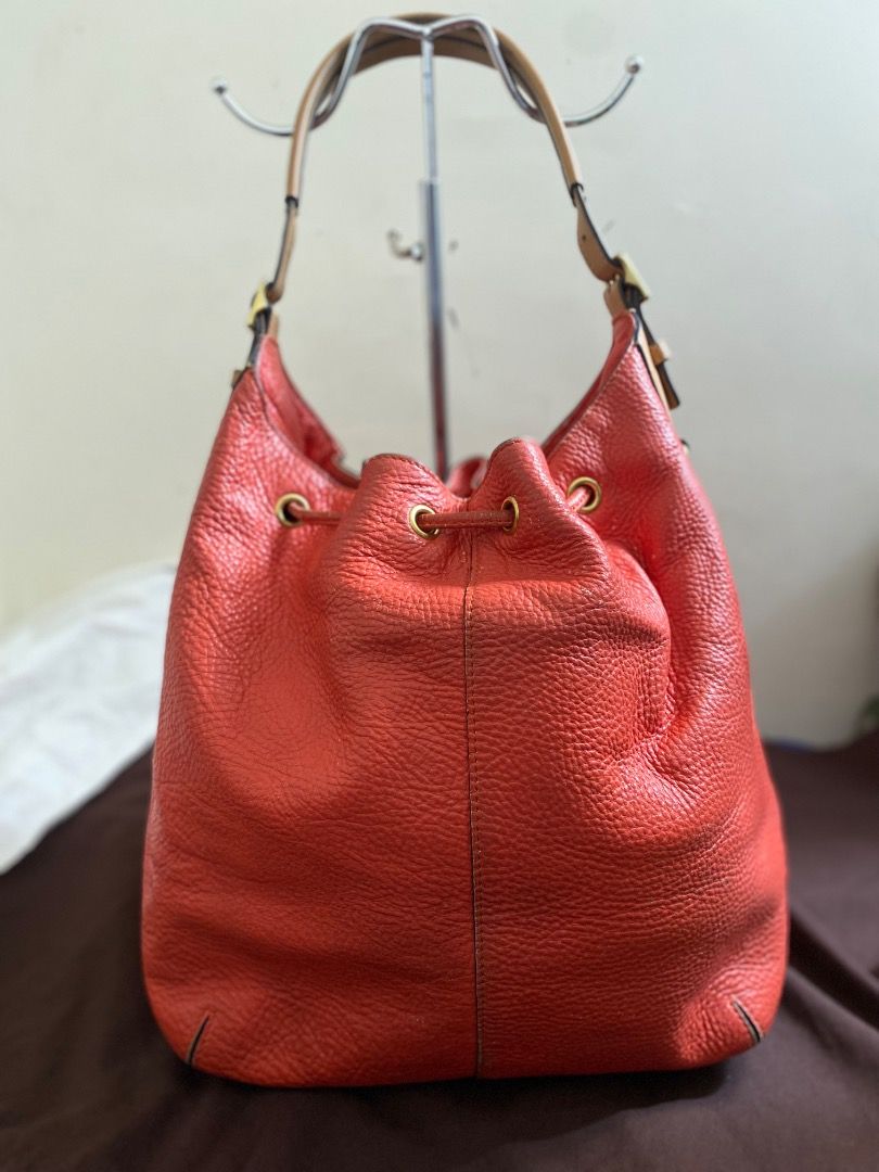Coach Orange Leather Drawstring Bucket Bag (Category: Luxury Bags & Wallets) located in Paete. Submitted by ladder_leynn (Listing ID 1440817041, Image 2). Description: - Authentic Coach bucket bag vintage - Vibrant orange pebbled leather - Tan leather straps - Secure drawstring closure - Elegant gold hardware details - Interior zip pocket for essentials - Made in China - Ideal everyday bag.