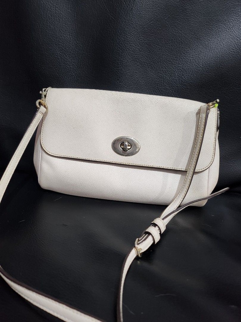 Coach White Turnlock Crossbody Bag (Category: Cross-body Bags) located in Cainta. Submitted by earthangeltin (Listing ID 1440849419, Image 2). Description: Selling my preloved Coach bag Rfs: Decluttering - Authentic Coach white canvas crossbody bag - Features a secure silver turnlock closure on the front flap - Adjustable strap for comfortable wear - Interior zip pocket for organized storage - Bag interior is clean Flaw: creed slightly peeled off