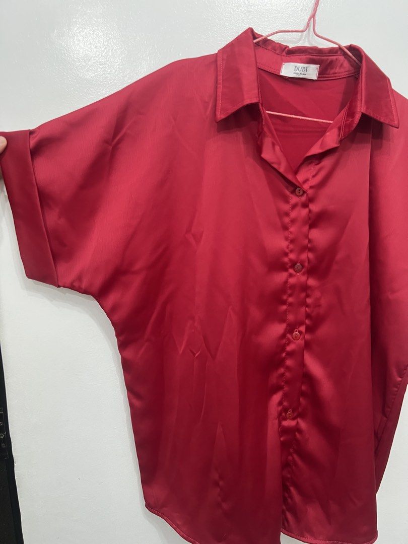 DUDE Red Satin Oversized Short Sleeve Button Up Shirt (Category: Shirts) located in Pasig City. Submitted by munchinitajanella (Listing ID 1440783045, Image 2). Description: - DUDE brand red satin shirt - Oversized fit - Short sleeves with cuffed detail - Button-up front - Perfect for casual wear or dressing up for a night out.