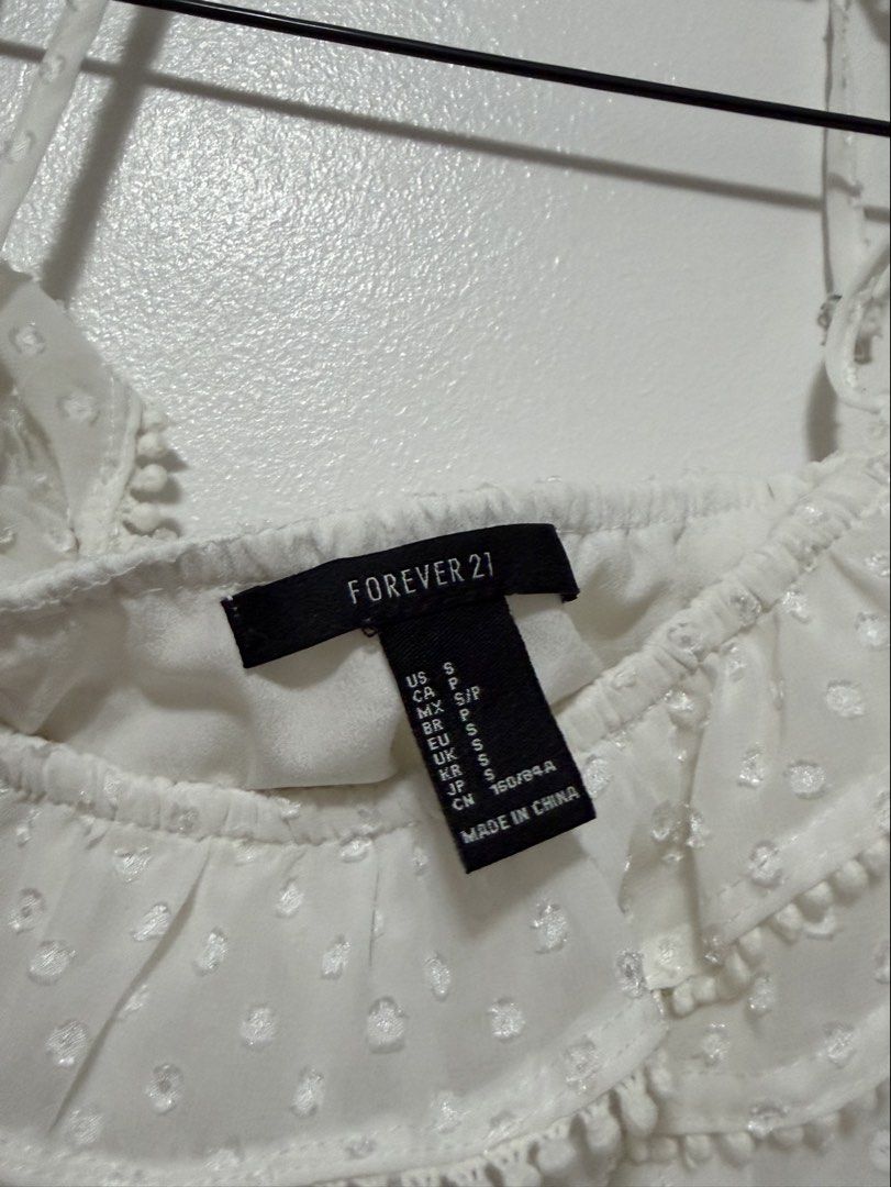 Forever 21 White Off-Shoulder Ruffle Crop Top (Category: Others Tops) located in Cabanatuan. Submitted by midaxadim (Listing ID 1440876935, Image 2). Description: - White off-shoulder crop top - Brand: Forever 21 - Features: Swiss dot pattern, ruffled trim, pom-pom details -Small on tag pero fits like XS po.