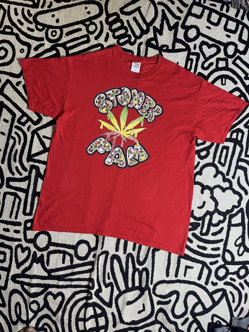 Gildan Stoner Fam Graphic Tee (Category: Tshirts & Polo Shirts ) located in Silang. Submitted by yusthrift (Listing ID 1440860933, Image 1). Description: - Red Gildan Heavy Cotton T-Shirt - Features 'Stoner Fam' graphic with cannabis leaf design - Size: Large - Perfect for casual wear - Shows some signs of wear, but plenty of life left - Please check photos for condition details Size: L on tag 22 inc width 28.5 inc length No issue Very good condi