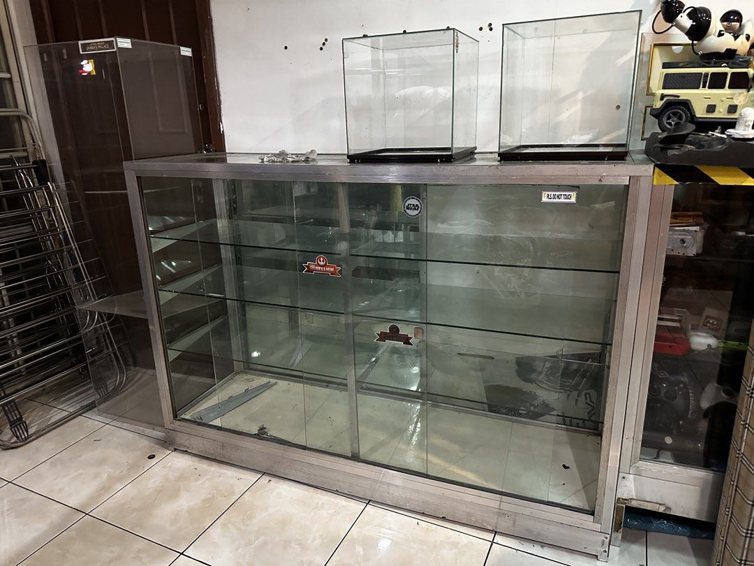 Glass Display Cabinet with Metal Frame (Category: Shelves, Cabinets & Racks) located in Marikina City. Submitted by mekanikko2026 (Listing ID 1440945512, Image 3). Description: - Glass display cabinet with sturdy metal frame - Features sliding glass doors for easy access - Multiple shelves for ample storage or display space - Decorated with cool Star Wars stickers on the glass - Perfect for shops, collectors, or home display - Pickup only.