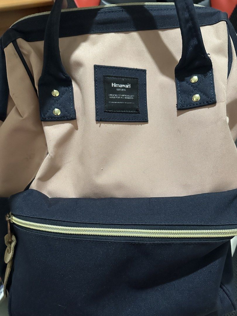 Authentic Himawari Backpack Navy Blue & Pink (Category: Backpacks) located in Caloocan City. Submitted by andreya87 (Listing ID 1440785163, Image 2). Description: - Himawari backpack with a stylish navy blue and pink two-tone canvas design. - Features multiple compartments inside for excellent organization. - Convenient side pockets, perfect for water bottles. - Comfortable padded straps for easy carrying. - All zippers are in smooth working cond