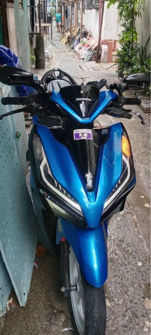 Honda Click 125i Motorcycle Blue (Category: Motorbikes for Sale) located in Quezon City. Submitted by jammatriano (Listing ID 1440863866, Image 1). Description: Honda Click 125i scooter in a vibrant blue. Has a sleek design with sharp headlights. The seat is covered with a black seat cover. White rims add a nice contrast. Ready for the road. Great for city commuting..