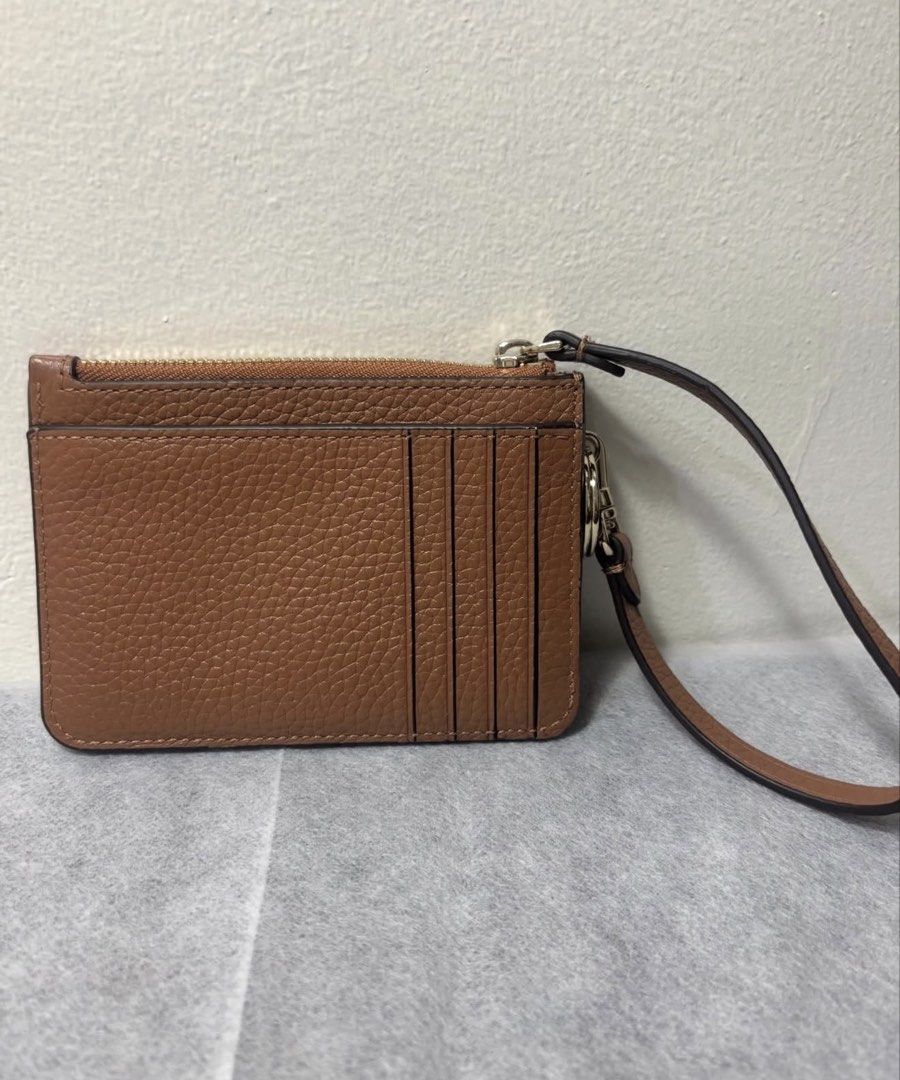 Kate Spade Brown Leather Cardholder Wristlet (Category: Wallets & Card holders) located in Mandaluyong City. Submitted by isydln (Listing ID 1440824973, Image 2). Description: -This is new without tag - Brand: Kate Spade - Material: Brown pebbled leather - Closure: Zip closure - Features: Wrist strap, multiple card slots on the back - Size: Small and compact - Ideal for: Everyday essentials, travel.