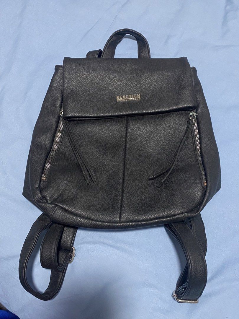 Kenneth Cole Backpack (Category: Backpacks) located in Manila. Submitted by mpt99876 (Listing ID 1440857725, Image 3). Description: - Brand: REACTION Kenneth Cole - Color: Black - Material: Faux Leather - Closure: Flap with magnetic snap - Exterior: Two zippered front pockets - Straps: Adjustable shoulder straps - Handle: Top carry handle - Ideal for: Everyday use or travel.