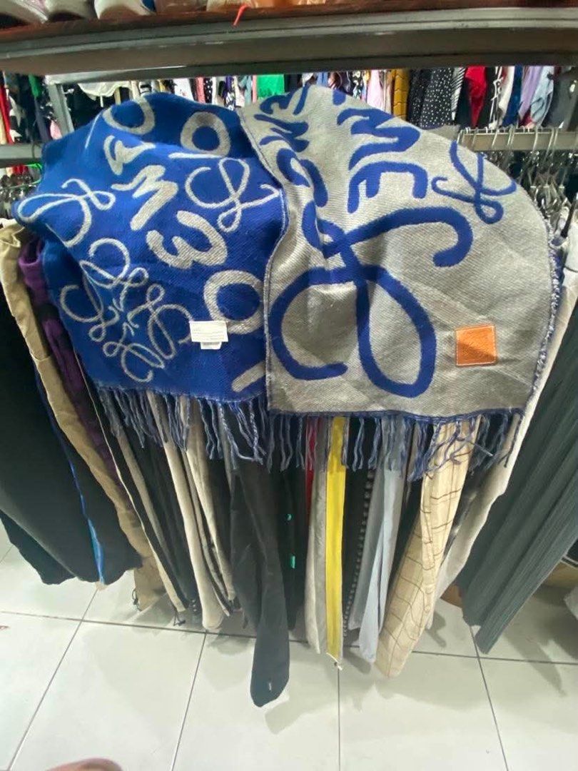 LOEWE Scarf Blue Grey Anagram Logo (Category: Luxury Accessories) located in Baguio. Submitted by cleverlion_e92944 (Listing ID 1440871729, Image 1). Description: - Authentic LOEWE scarf - Iconic Anagram logo in blue and grey - Fringed edges - Made in UK - Approx. [insert length] x [insert width] inches - Perfect for adding a pop of color and luxury - Please check photos for detailed condition.