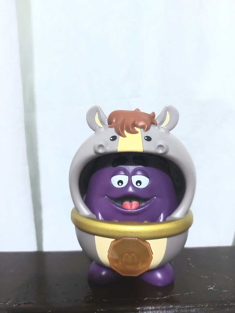 McDonald's Grimace Toy in Horse Costume (Category: Character Goods) located in Manila. Submitted by nicolezald25729 (Listing ID 1440896607, Image 1). Description: - McDonald's Grimace Chineze Zodiac Happy Meal collectible toy. - Grimace is dressed in a charming horse costume. - Features Grimace's iconic purple color and happy expression. - Costume is grey with detailed horse ears and mane. - Includes a stylish gold band around the middle. - McDon