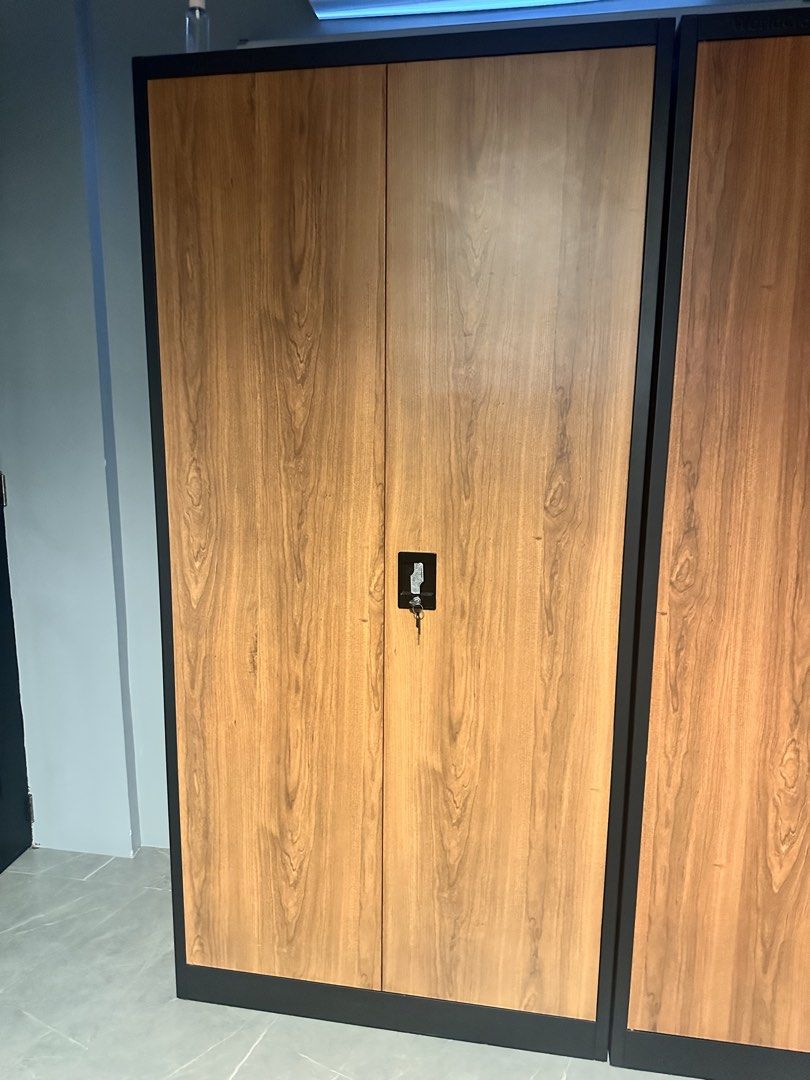 Metal Wardrobe with Wood Grain Doors (Category: Shelves, Cabinets & Racks) located in Cavite. Submitted by angelistuff (Listing ID 1440799324, Image 2). Description: - Two-door metal wardrobe - Wood grain finish - Includes hanging rod and shelf - Lockable doors for security - Ideal for clothes and storage - Dimensions: Approx. 180cm (H) x 90cm (W) x 45cm (D) - Sold as a pair - Pick up only.