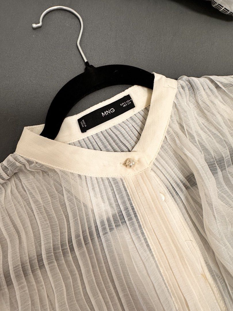 MNG Cream Pleated Long Sleeve Button Up Blouse (Category: Blouses) located in Manila. Submitted by shannenvel63434 (Listing ID 1440898977, Image 3). Description: - Cream colored MNG blouse - Long sleeves with pleated details - Button up front with a unique collar button - Sheer fabric with vertical pleats all over - Versatile for dressing up or down - Perfect for layering.