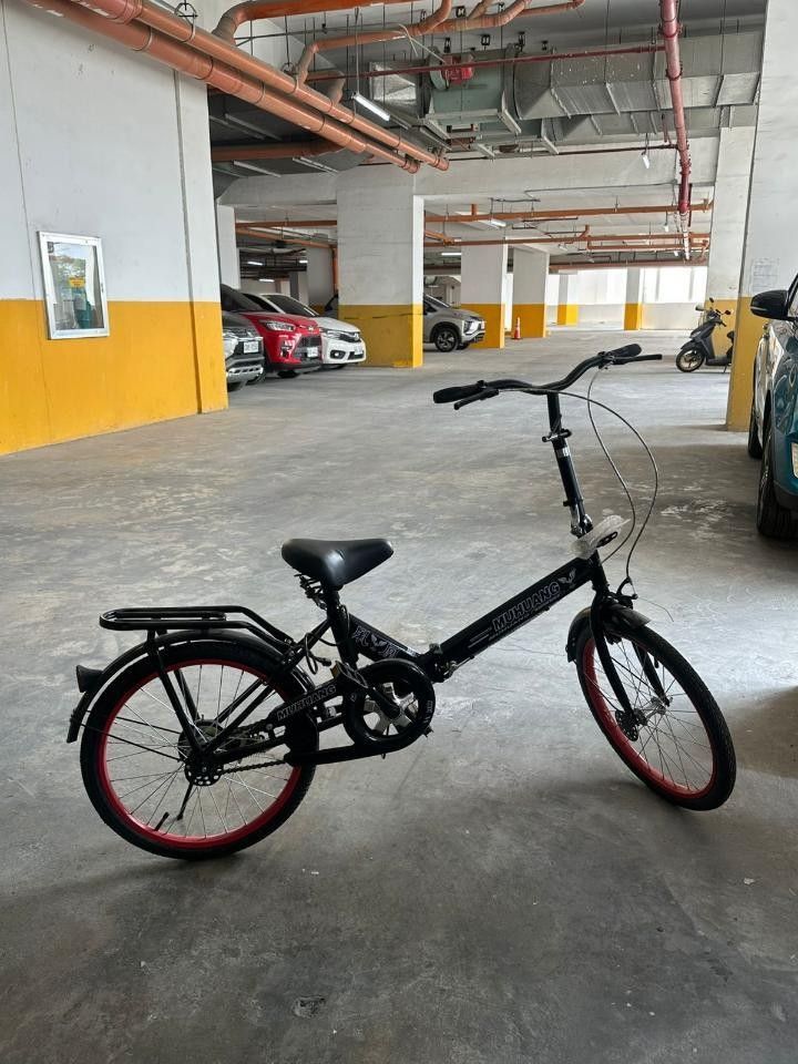 Folding Bicycle with Red Rims (Category: Bicycles) located in Mandaluyong City. Submitted by prelovedbythebabs (Listing ID 1440901164, Image 1). Description: - Black folding bike with stylish red rim accents - Convenient rear rack for carrying essentials - Ideal for space-saving storage - Ready for its next adventure! - Negotiable Note: Slight issue on stem lock lever handle bar..