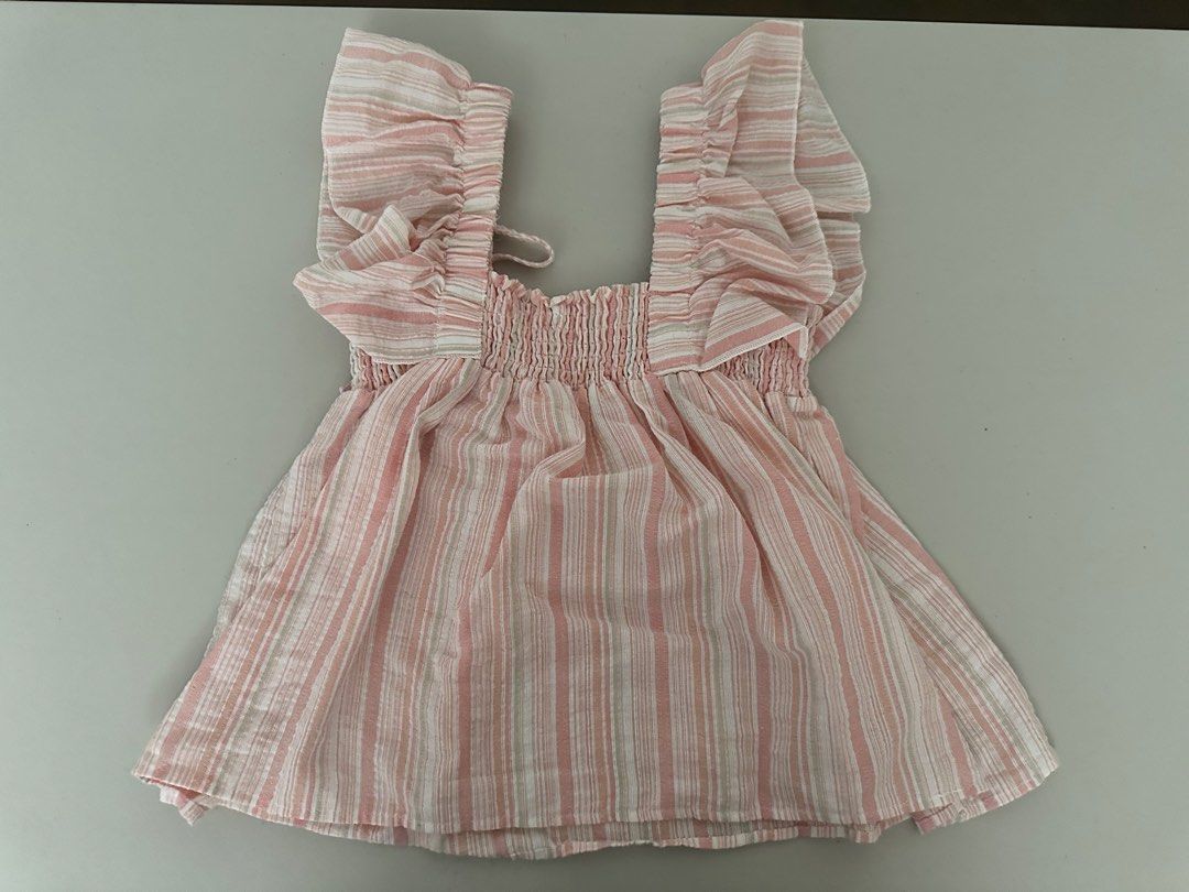 Pink Striped Smocked Square Neck Flutter Sleeve Top (Category: Blouses) located in Pasig City. Submitted by repurposed.2021 (Listing ID 1440820015, Image 1). Description: - Cute pink and white striped design - Square neckline with smocking detail - Flattering flutter sleeves - Adjustable front tie - Lightweight fabric, ideal for hot weather - Versatile: pairs easily with shorts or jeans.