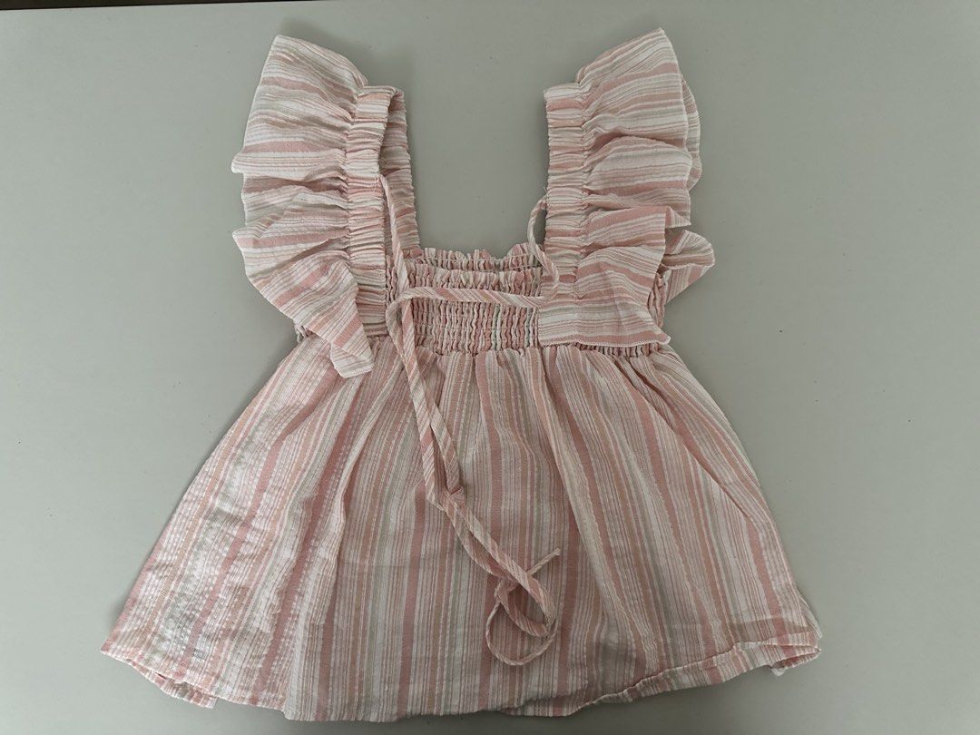 Pink Striped Smocked Square Neck Flutter Sleeve Top (Category: Blouses) located in Pasig City. Submitted by repurposed.2021 (Listing ID 1440820015, Image 2). Description: - Cute pink and white striped design - Square neckline with smocking detail - Flattering flutter sleeves - Adjustable front tie - Lightweight fabric, ideal for hot weather - Versatile: pairs easily with shorts or jeans.