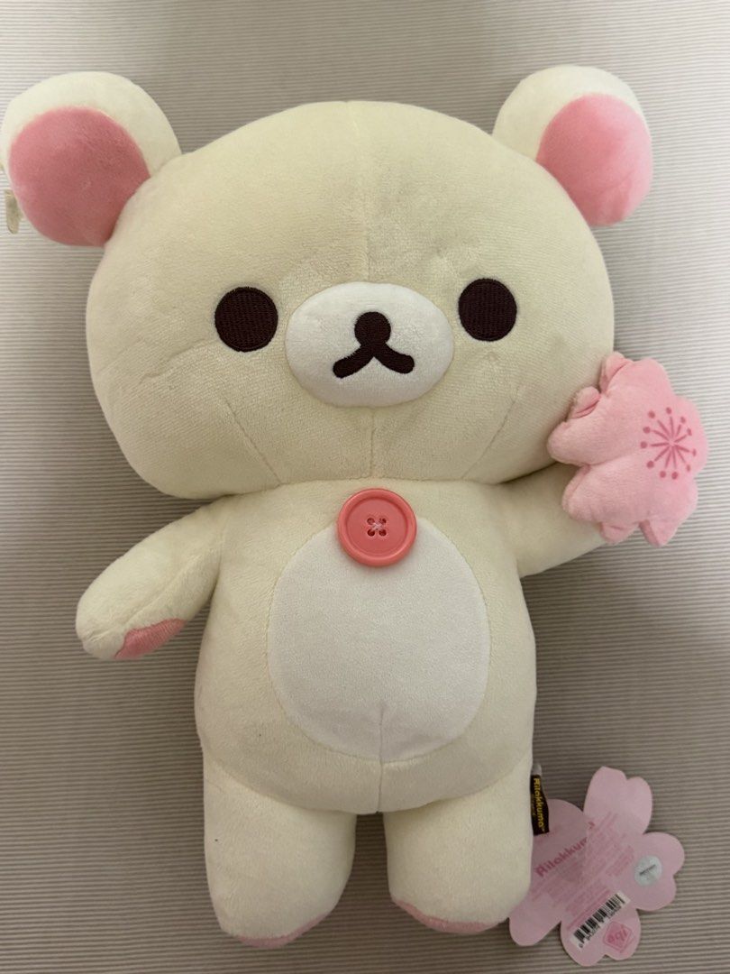San-X Rilakkuma Cherry Blossom Plush (Category: Plushies & Soft Toys) located in Manila. Submitted by happymelona (Listing ID 1440919449, Image 1). Description: - Adorable Rilakkuma plush toy - Cream color with sweet pink accents on ears and paws - Features a cute pink button on its belly - Holding a delicate cherry blossom flower - Comes with original tags attached - Ideal for Rilakkuma collectors - Makes a wonderful gift!.