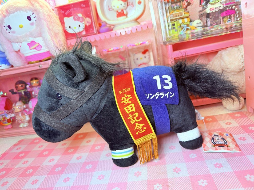 Thoroughbred Horse (Category: Plushies & Soft Toys) located in Caloocan City. Submitted by fluffy.stuff10 (Listing ID 1440766009, Image 1). Description: - Adorable black horse plush toy. - Blue saddle cloth with '13' and 'ソングライン' (Songline). - Red and gold sash commemorating the '第72回 安田記念' (72nd Yasuda Kinen). - Ideal for collectors and horse racing enthusiasts. - Comes with its original tag..