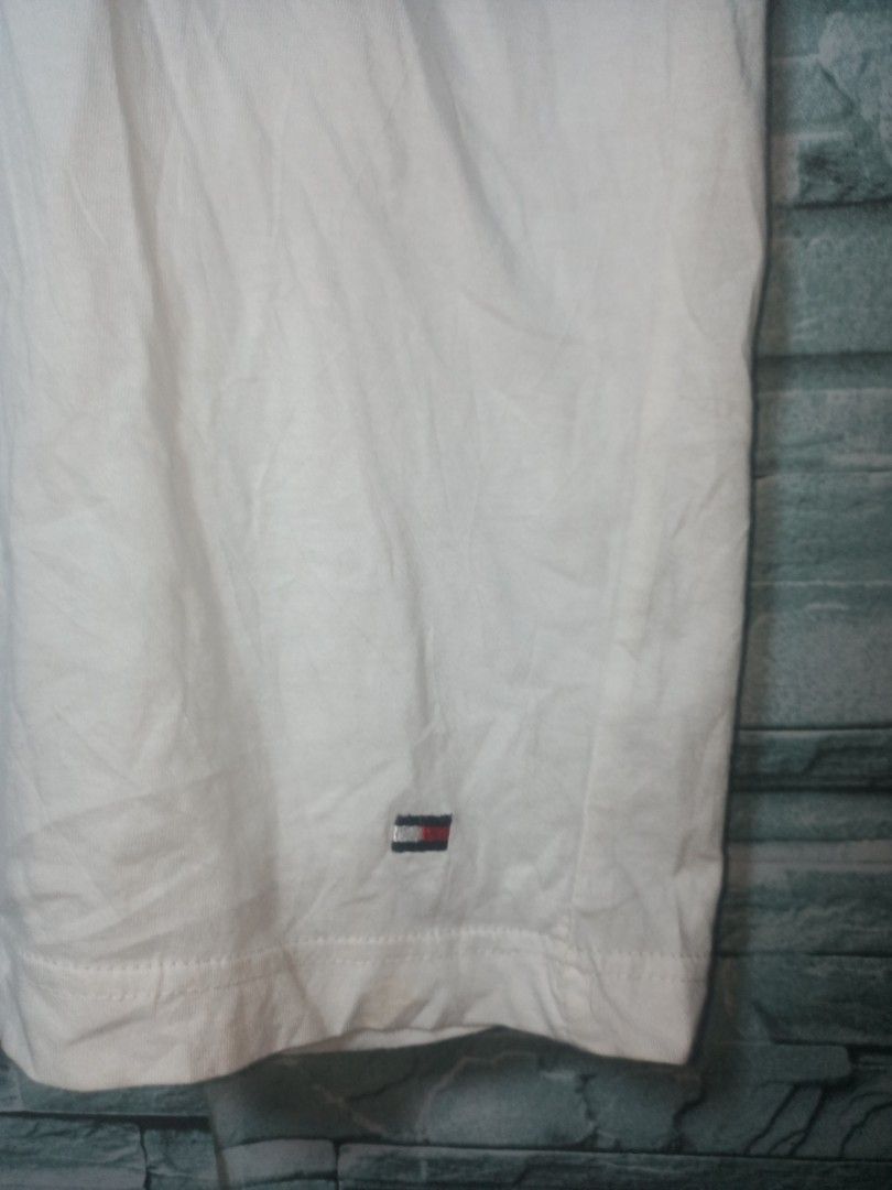 Tommy Hilfiger White T-Shirt (Category: Tshirts & Polo Shirts ) located in Quezon City. Submitted by apconcept22 (Listing ID 1440830248, Image 2). Description: - Classic white Tommy Hilfiger t-shirt - Features the iconic Tommy flag logo on the hem - Size L - Versatile for everyday wear - Easy to pair with any outfit.