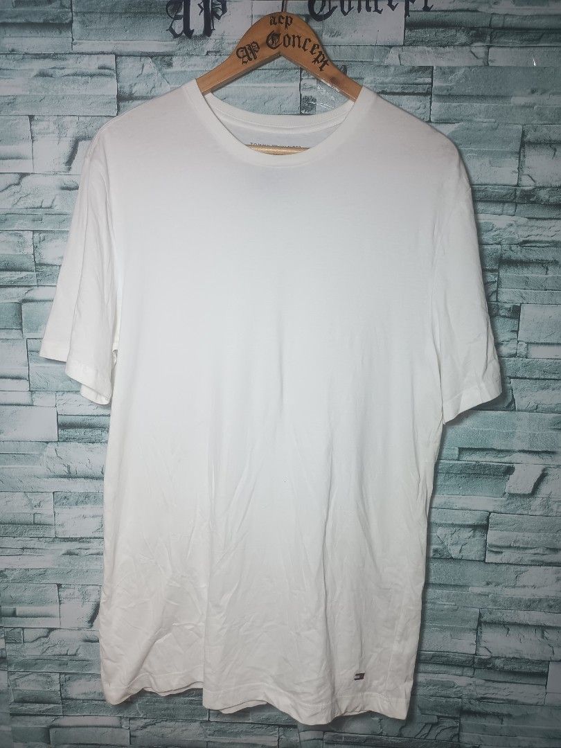 Tommy Hilfiger White T-Shirt (Category: Tshirts & Polo Shirts ) located in Quezon City. Submitted by apconcept22 (Listing ID 1440830248, Image 1). Description: - Classic white Tommy Hilfiger t-shirt - Features the iconic Tommy flag logo on the hem - Size L - Versatile for everyday wear - Easy to pair with any outfit.