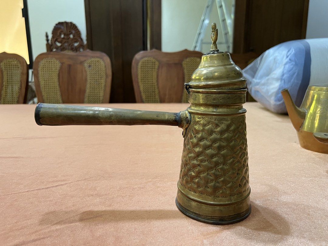 Vintage Brass Coffee Pot with Handle and Lid (Category: Coffee & Tea Tableware) located in Paranaque City. Submitted by mariafernandez917 (Listing ID 1440905205, Image 1). Description: - Antique brass coffee pot - Features intricate patterned detailing all over the body - Long handle for easy handling - Decorative lid with a charming bird finial - Perfect for display or as a unique kitchen accent.