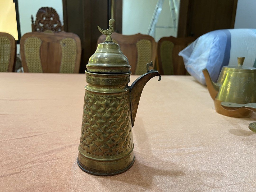 Vintage Brass Coffee Pot with Handle and Lid (Category: Coffee & Tea Tableware) located in Paranaque City. Submitted by mariafernandez917 (Listing ID 1440905205, Image 2). Description: - Antique brass coffee pot - Features intricate patterned detailing all over the body - Long handle for easy handling - Decorative lid with a charming bird finial - Perfect for display or as a unique kitchen accent.