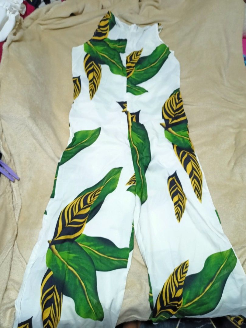 White Jumpsuit with Green Leaf Print (Category: Jumpsuits) located in Rizal. Submitted by declutterprod (Listing ID 1440802034, Image 1). Description: - White jumpsuit with a bold green leaf print - Sleeveless design - Wide leg silhouette - Ideal for casual wear or vacation - Comfortable and easy to style with sandals or sneakers.