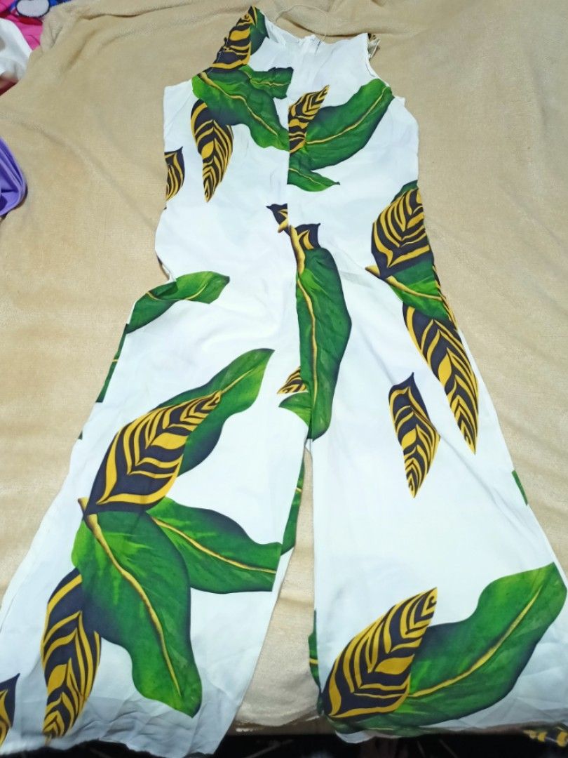 White Jumpsuit with Green Leaf Print (Category: Jumpsuits) located in Rizal. Submitted by declutterprod (Listing ID 1440802034, Image 2). Description: - White jumpsuit with a bold green leaf print - Sleeveless design - Wide leg silhouette - Ideal for casual wear or vacation - Comfortable and easy to style with sandals or sneakers.