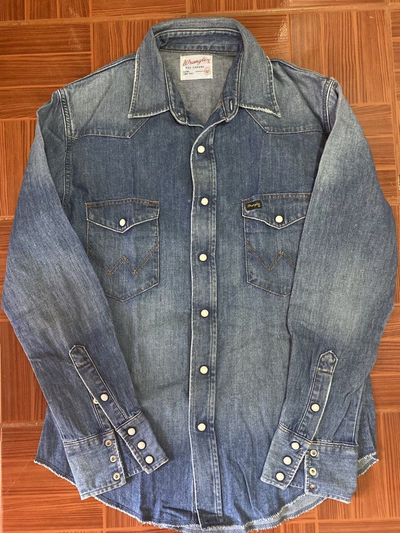 Wrangler Pre-Shrunk Denim Western Shirt (Category: Tshirts & Polo Shirts ) located in Pasig City. Submitted by 3ekcim (Listing ID 1440811541, Image 1). Description: - Classic blue denim western shirt by Wrangler. - Pre-shrunk fabric for a consistent fit. - Features iconic Wrangler logo on chest pocket. - Genuine pearl snap buttons. - Traditional long tails design. - Perfect for casual outfits or layering..