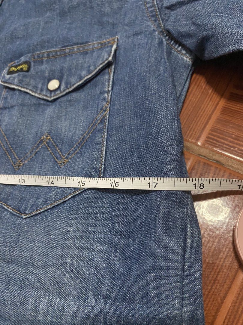Wrangler Pre-Shrunk Denim Western Shirt (Category: Tshirts & Polo Shirts ) located in Pasig City. Submitted by 3ekcim (Listing ID 1440811541, Image 3). Description: - Classic blue denim western shirt by Wrangler. - Pre-shrunk fabric for a consistent fit. - Features iconic Wrangler logo on chest pocket. - Genuine pearl snap buttons. - Traditional long tails design. - Perfect for casual outfits or layering..
