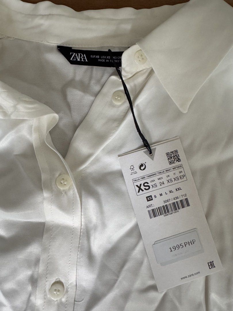 Zara White Button-Up Shirt XS (Category: Shirts) located in Silang. Submitted by xoxovintage98 (Listing ID 1440768473, Image 3). Description: - Brand: Zara - Type: Button-up Shirt - Color: White - Size: XS - Features: Long sleeves with button cuffs, classic collar - Fit: Slightly oversized - Condition: New with original tags attached - Versatility: Great for casual or work wear.