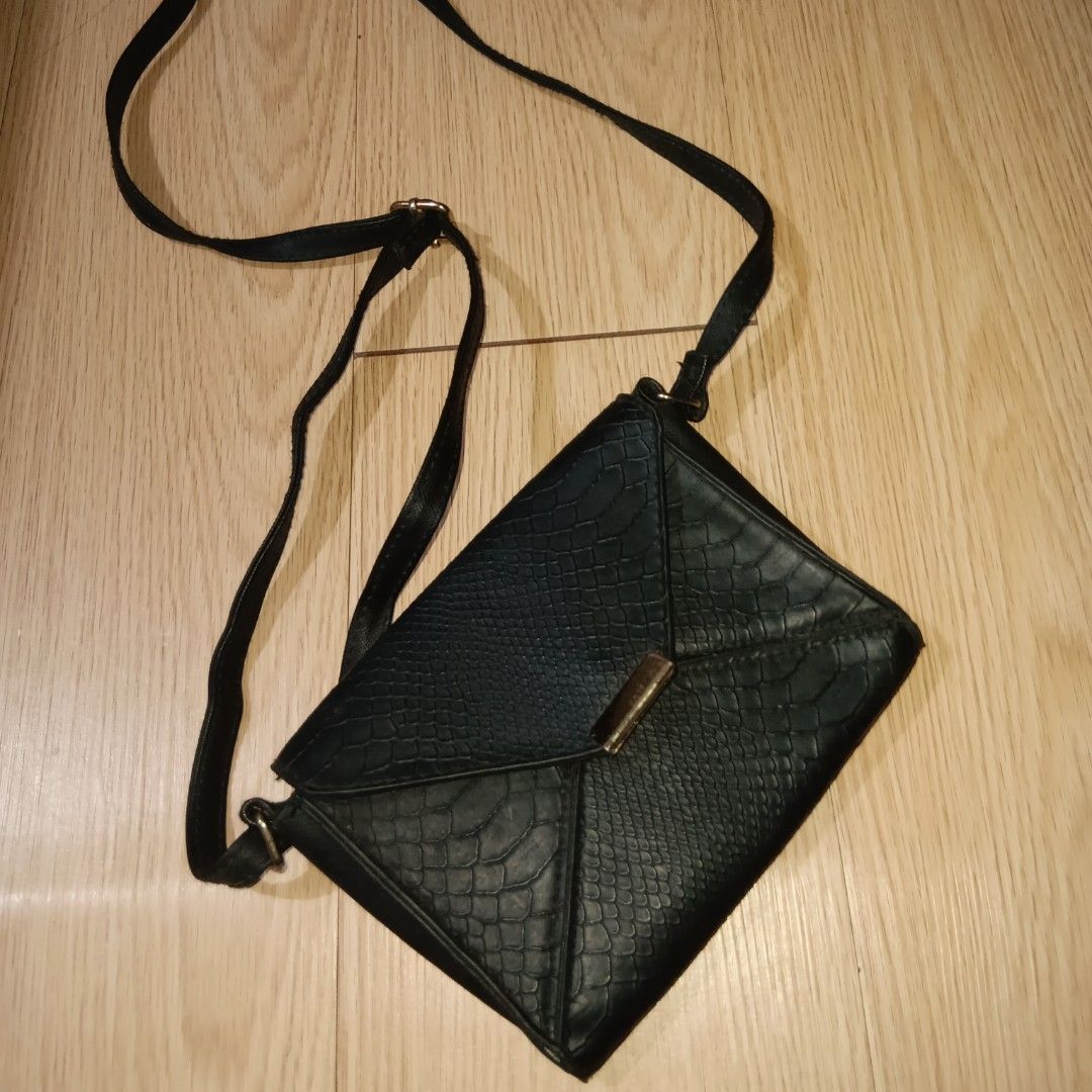 Black Envelope Style Crossbody Bag (Category: Cross-body Bags) located in Taguig. Submitted by ncomn (Listing ID 1441089654, Image 1). Description: - Black envelope-style crossbody bag with snake print texture and adjustable strap - Interior zippered compartment fits small essentials - Used condition, with slight rusting on the front hardware design - Pls manage your expectations.