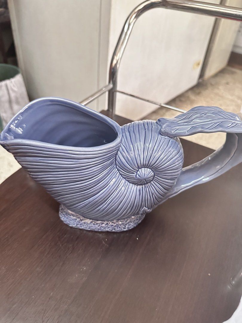 Blue Seashell Ceramic Gravy Boat (Category: Coffee & Tea Tableware) located in Quezon City. Submitted by mystictiger.019d9c (Listing ID 1441095866, Image 1). Description: - Unique blue ceramic pitcher - Shaped like a seashell - Ideal for serving drinks or as a decorative piece - Features a lovely shiny glaze - Handle designed like a shell's fin - Base has a textured finish - Adds a coastal vibe to any setting.