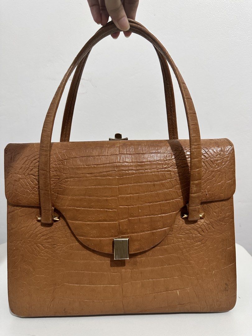 Brown Genuine Wild Crocodile Handbag (Category: Luxury Bags & Wallets) located in Rizal. Submitted by pearlbagcollection (Listing ID 1441143973, Image 1). Description: - Classic brown handbag - Genuine Crocodile texture - Secure gold-tone clasp closure - Sturdy and comfortable top handles - Timeless vintage flair - Versatile for everyday or special occasions.