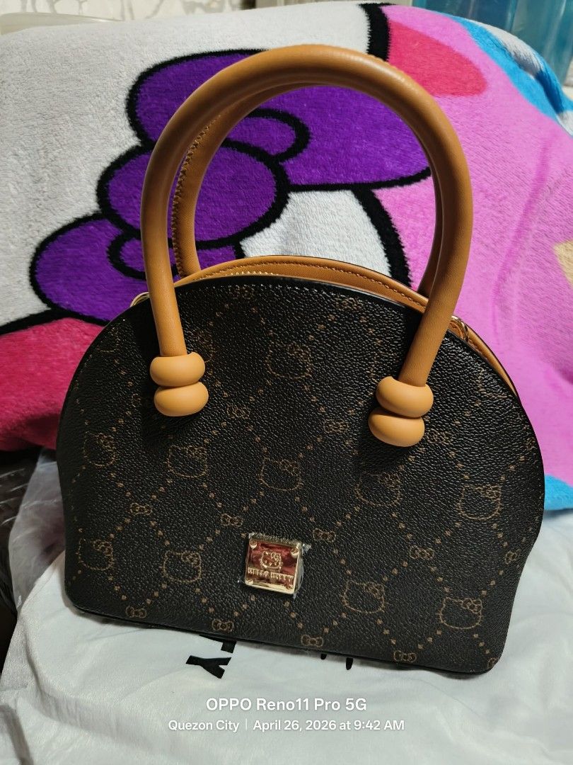 Brown Hello Kitty Monogram Mini Handbag (Category: Purses & Pouches) located in San Pedro. Submitted by kittyaly (Listing ID 1440967002, Image 1). Description: Cute brown mini handbag with Kitty pattern. Tan handles and trim. Zipper closure. Interior has a zipped pocket and a strap. Small metal logo plate on the front. Comes with a dust bag. Great for carrying essentials..