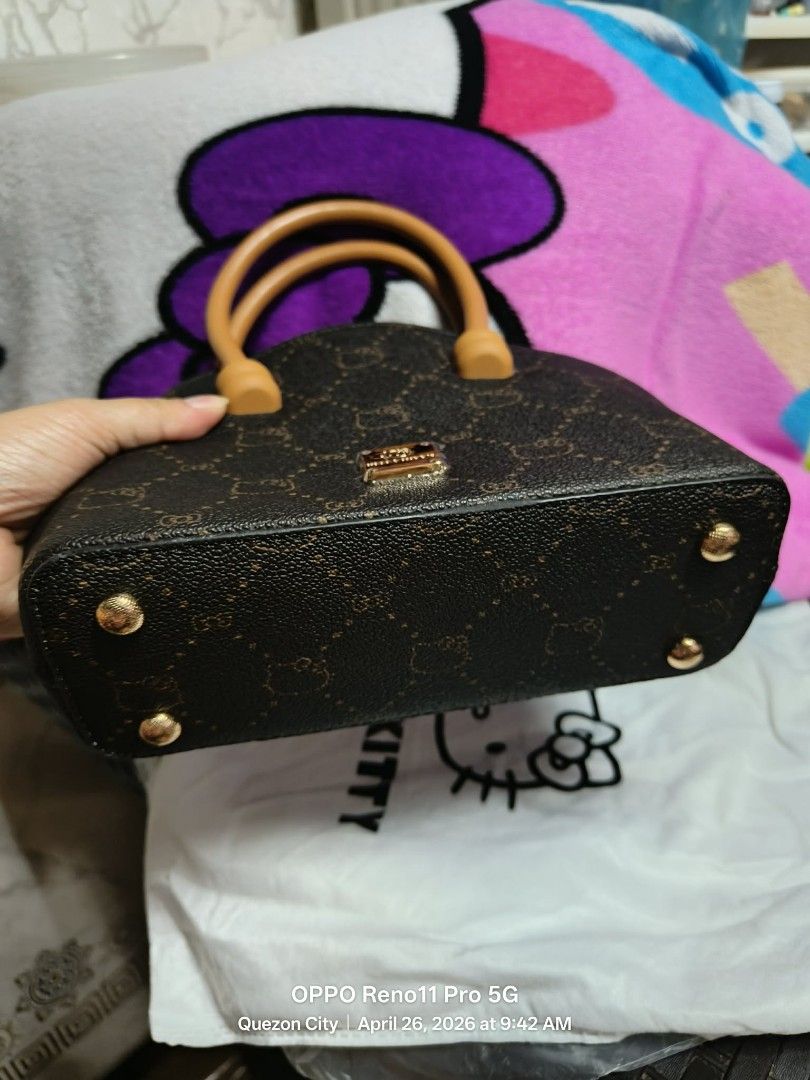 Brown Hello Kitty Monogram Mini Handbag (Category: Purses & Pouches) located in San Pedro. Submitted by kittyaly (Listing ID 1440967002, Image 3). Description: Cute brown mini handbag with Kitty pattern. Tan handles and trim. Zipper closure. Interior has a zipped pocket and a strap. Small metal logo plate on the front. Comes with a dust bag. Great for carrying essentials..