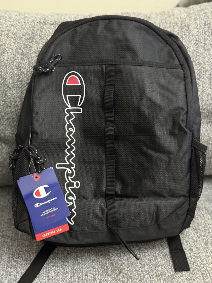 Champion Backpack Black (Category: Backpacks) located in Pasig City. Submitted by shopwithelle__ (Listing ID 1441139950, Image 1). Description: - Classic black Champion backpack - Features iconic Champion logo on the front - Spacious main compartment with a vibrant blue interior - Includes a convenient inner mesh pocket - Padded shoulder straps for maximum comfort - Dual side mesh pockets, ideal for water bottles - Versatile for school, work, or 