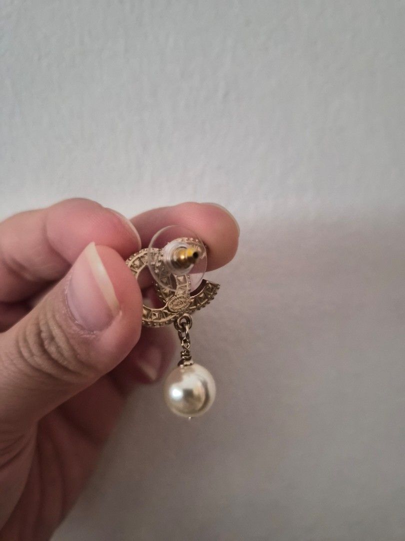 Chanel CC Pearl Drop Earrings Gold (Category: Earrings) located in Singapore. Submitted by nicki3 (Listing ID 1440964332, Image 3). Description: - Classic Chanel earrings - Iconic CC logo with pearl drop - Gold tone finish - Accented with small crystals on the CC - Comes with original box - Perfect for elevating any outfit.