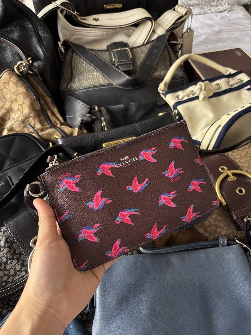 Coach Brown Bird Print Wristlet Pouch with Strap (Category: Purses & Pouches) located in Manila. Submitted by mpt99876 (Listing ID 1440994151, Image 1). Description: - Cute Coach wristlet pouch - Color: Brown with fun pink and blue bird print - Features a zippered closure - Interior card slots for organization - Includes care instructions and authenticity card - Ideal for keeping your essentials handy.
