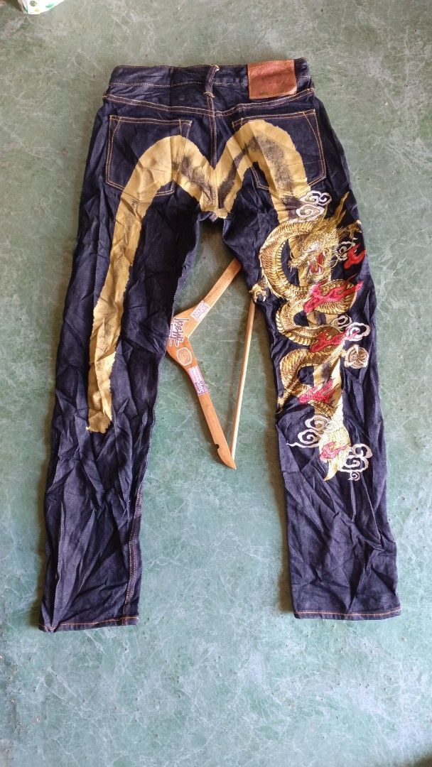 EVISU Jeans Dragon Embroidery Size 29 (Category: Jeans) located in Cateel. Submitted by tsedrickra31083 (Listing ID 1441095391, Image 2). Description: - Dark wash EVISU jeans - Size 30 waist - Large dragon and wave embroidery on back - Orange contrast stitching throughout - Button fly closure - Ideal for streetwear enthusiasts.