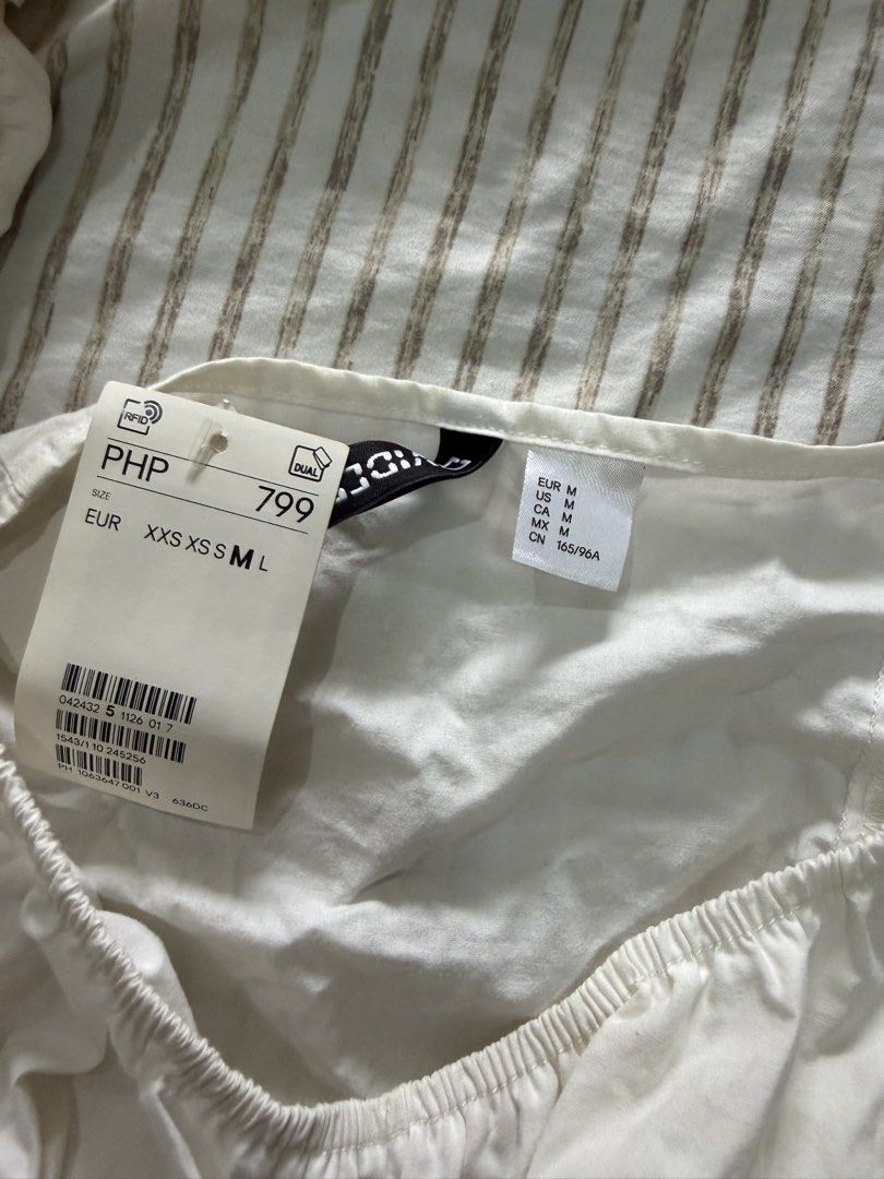 H&M White Puff Sleeve Tie Front Crop Top (Category: Blouses) located in Manila. Submitted by mento.ph (Listing ID 1441040538, Image 2). Description: - White puff sleeve crop top from H&M - Square neckline with tie front detail - Size: Medium (M) - Brand new with original tag attached.