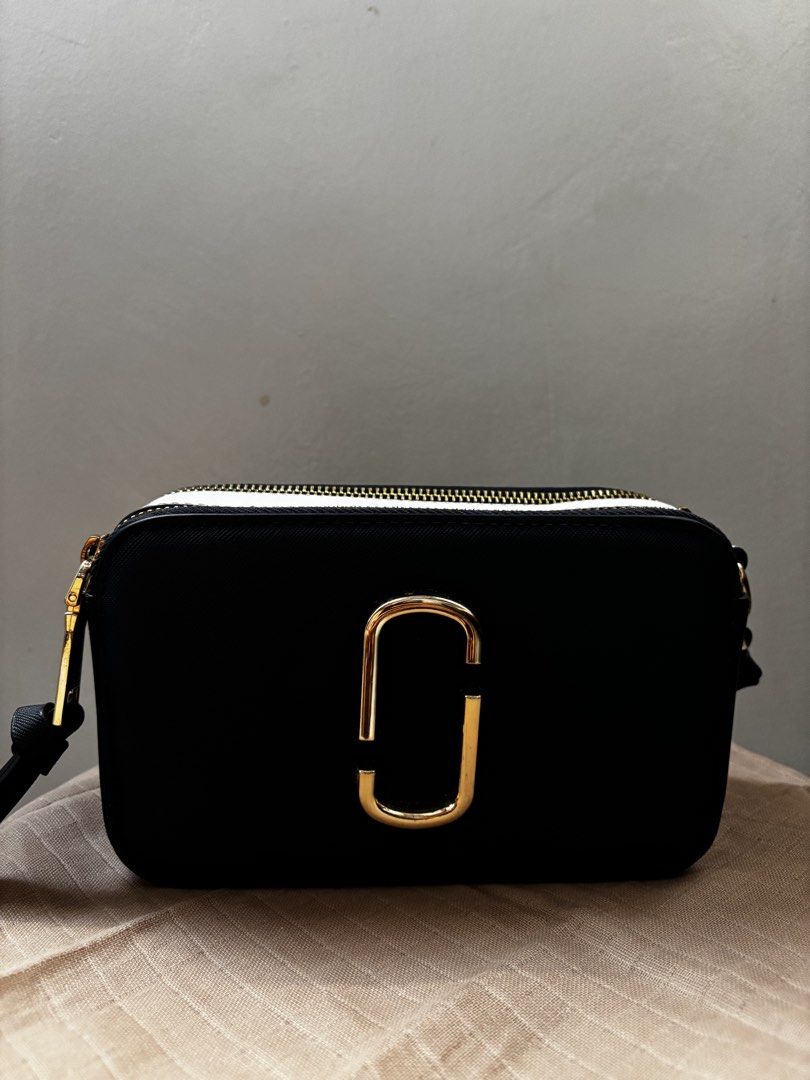 Marc Jacobs Snapshot Camerka Bag Black Gold Strap (Category: Luxury Bags & Wallets) located in Santa. Submitted by catherinee. (Listing ID 1441154887, Image 3). Description: - Authentic Black Marc Jacobs Snapshot bag - Gold hardware and logo - Includes signature "The Marc Jacobs" strap - White trim detail on top - Ideal for everyday use - Fits all your essentials • perfect for errands, or casual outings! 📍Ilocos Sur 📩Message for any inquiries! 