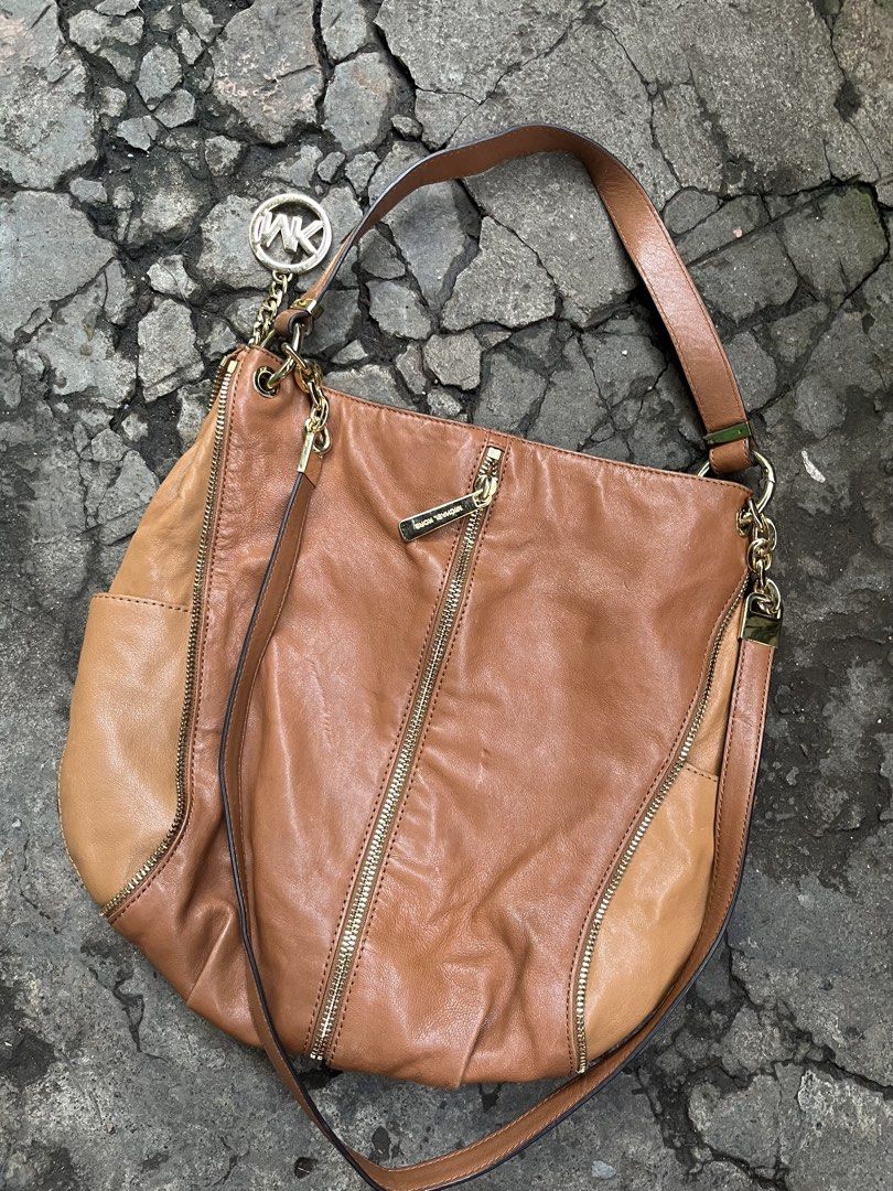 Michael Kors Leather Hobo Bag - Brown (Category: Luxury Bags & Wallets) located in Muntinlupa City. Submitted by cutiepie143 (Listing ID 1441067479, Image 2). Description: - Genuine brown leather Michael Kors hobo bag - Elegant gold-tone hardware with signature MK charm - Stylish zipper details on the front - Comfortable single shoulder strap with chic chain accents - Spacious interior, ideal for everyday essentials - A versatile and fashionable 