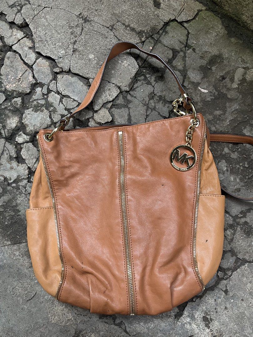 Michael Kors Leather Hobo Bag - Brown (Category: Luxury Bags & Wallets) located in Muntinlupa City. Submitted by cutiepie143 (Listing ID 1441067479, Image 1). Description: - Genuine brown leather Michael Kors hobo bag - Elegant gold-tone hardware with signature MK charm - Stylish zipper details on the front - Comfortable single shoulder strap with chic chain accents - Spacious interior, ideal for everyday essentials - A versatile and fashionable 