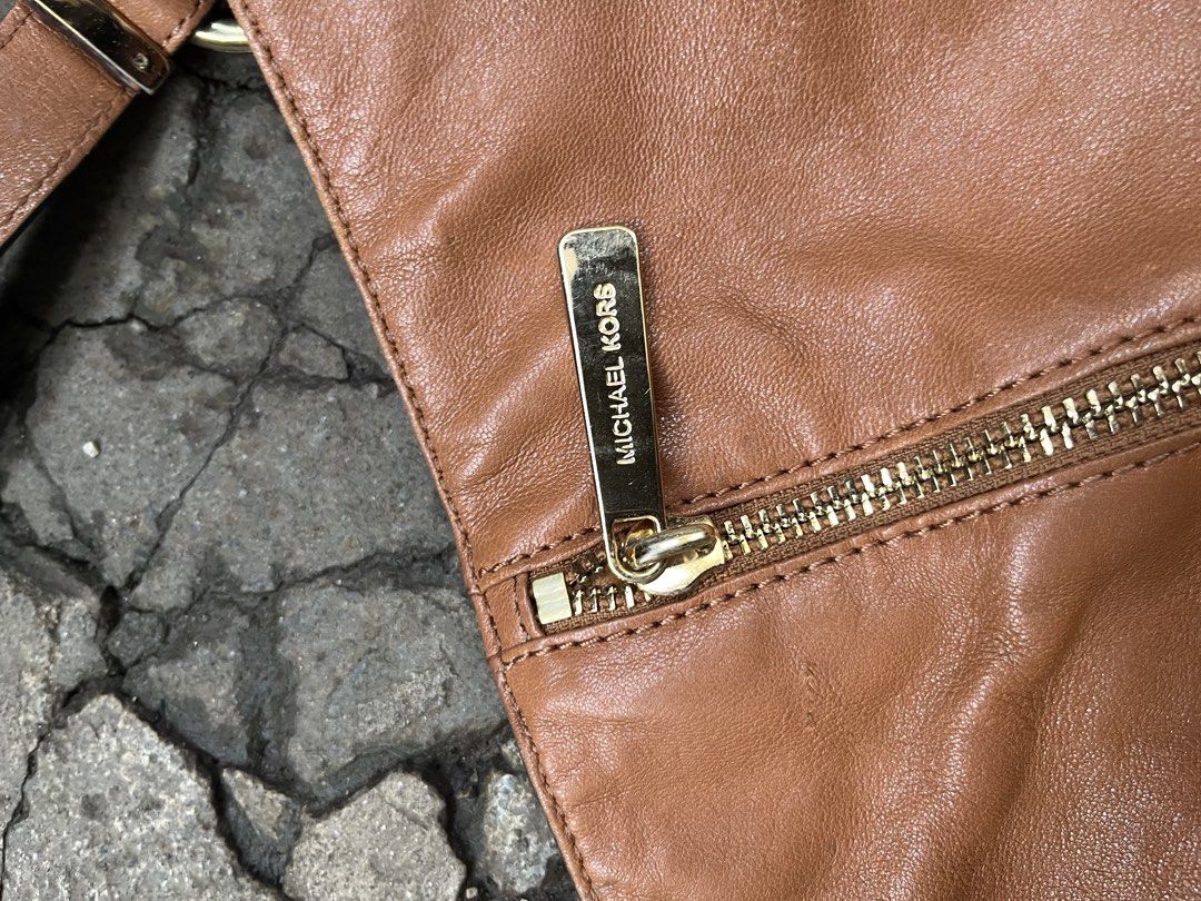 Michael Kors Leather Hobo Bag - Brown (Category: Luxury Bags & Wallets) located in Muntinlupa City. Submitted by cutiepie143 (Listing ID 1441067479, Image 3). Description: - Genuine brown leather Michael Kors hobo bag - Elegant gold-tone hardware with signature MK charm - Stylish zipper details on the front - Comfortable single shoulder strap with chic chain accents - Spacious interior, ideal for everyday essentials - A versatile and fashionable 