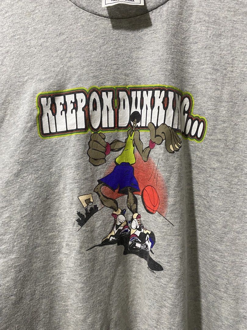 Nike "Keep On Dunking" Graphic T-Shirt Size S (Category: Tshirts & Polo Shirts ) located in Bansud. Submitted by vintagebynitram (Listing ID 1441067575, Image 3). Description: - Grey Nike T-shirt - Size: S - Front graphic: 'Keep On Dunking' with cartoon basketball players - Back graphic: 'THUNK!' - Material: Made in China - Ideal for: Casual wear.