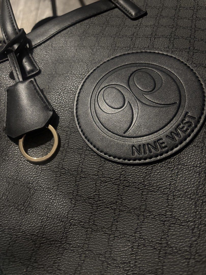 Nine West Tote Bag with Shoulder Strap (Category: Tote Bags) located in Makati City. Submitted by shelfdestash (Listing ID 1441062128, Image 3). Description: - Stylish black Nine West tote bag - All-over signature Nine West logo pattern - Includes a detachable shoulder strap - Elegant gold hardware accents - Interior zippered compartments for organization - Ideal for everyday errands or travel adventures.