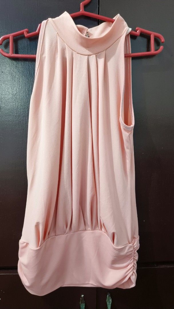 Pink Sleeveless Mock Neck Ruched Hem Top (Category: Sleeveless) located in Quezon City. Submitted by eniger. (Listing ID 1441045778, Image 1). Description: - Soft pink sleeveless top - Mock neck with elegant front draping - Ruched detailing on both sides of the hem - Keyhole cutout at the back with pearl button closure - Perfect for dressing up or down.