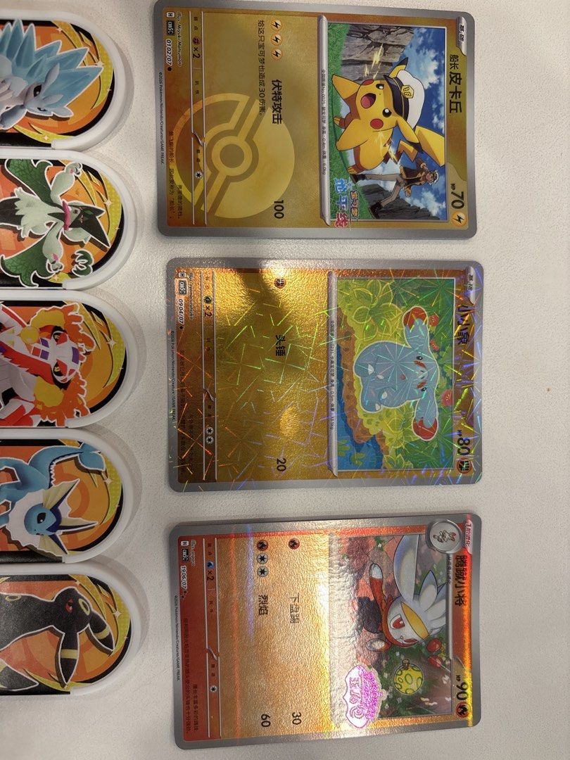 Pokemon Cards and Mezatags (Category: Raw Singles) located in Manila. Submitted by andreiambi74724 (Listing ID 1441049634, Image 2). Description: - Collection of Pokemon battle tokens and cards - Features popular Pokemon like Pikachu, Umbreon, and Vaporeon - Includes holographic cards for added rarity - Tokens display Pokemon characters and battle stats - Perfect for any Pokemon fan or collector.